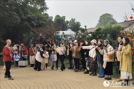 葉科（左一）給前來參與活動(dòng)的“柑爸柑媽”介紹生態(tài)種植果。人民網(wǎng)記者朱虹攝