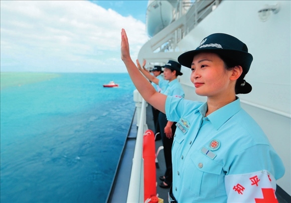中國海軍“和平方舟”號醫(yī)院船結(jié)束訪問湯加時，任務(wù)官兵中的文職人員向歡送人群揮手告別（2023年8月4日攝）。徐巍攝/本刊