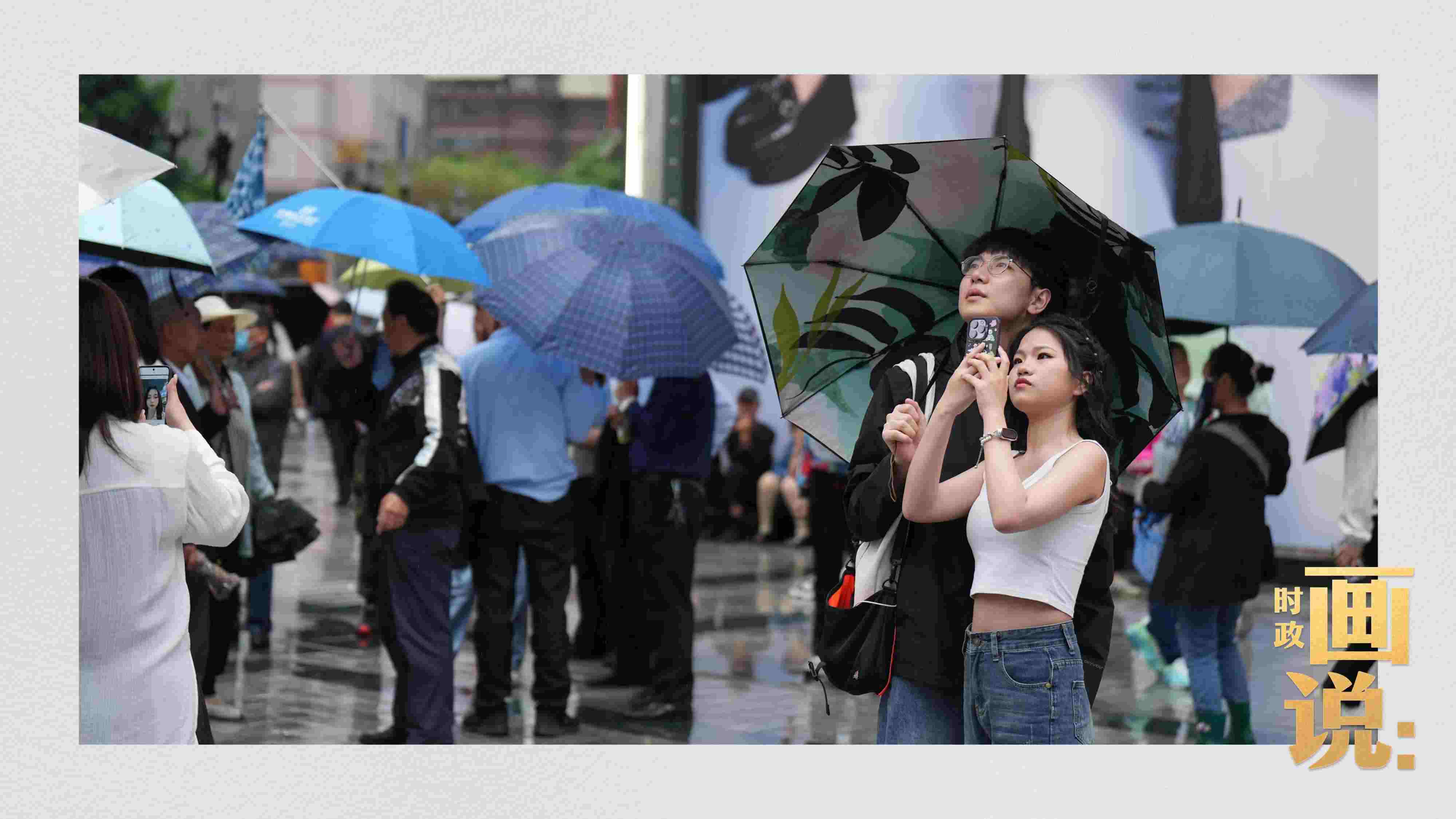 △細(xì)雨中的解放碑步行街，騎在父親肩膀的小女孩好奇張望。
