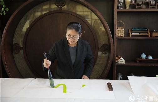 緬甸駐華大使館副館長、公使銜參贊杜欣瑪泰參加《五百筆·瀾湄合作》集體藝術(shù)創(chuàng)作。人民網(wǎng)王婧攝