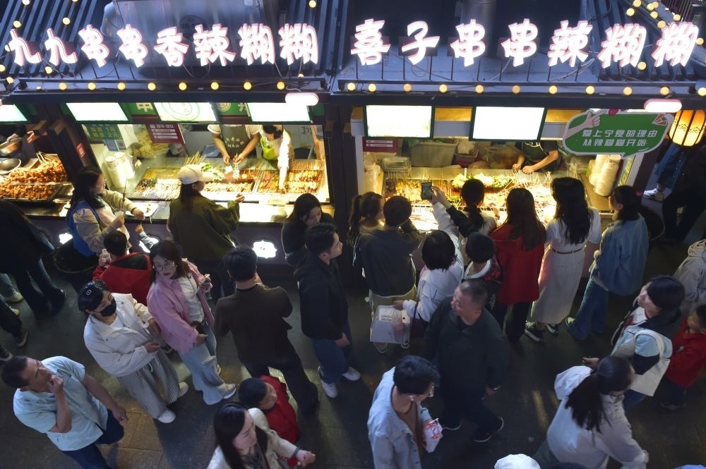 2024年5月4日，游客在寧夏銀川懷遠(yuǎn)夜市品嘗當(dāng)?shù)鼐W(wǎng)紅美食辣糊糊。新華社記者 毛竹 攝