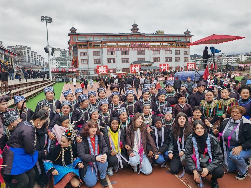 法國(guó)青年在“村超”賽場(chǎng)邊與參加表演的村民合影。新華社記者 羅羽 攝