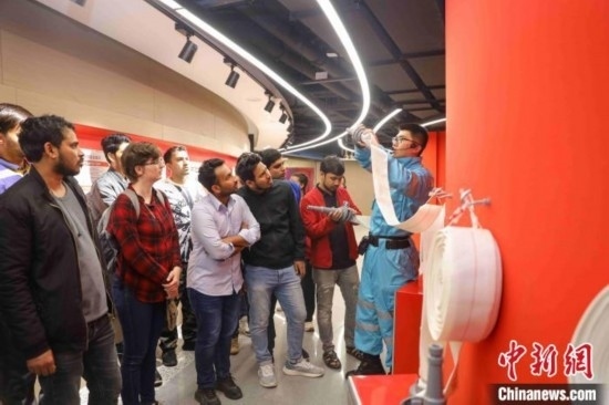 5月9日，工作人員指導留學生正確使用消防水帶。張鷹 攝