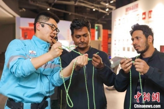 5月9日，工作人員指導留學生學習打繩結。張鷹 攝