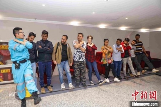 5月9日，工作人員指導留學生練習逃生技巧。張鷹 攝