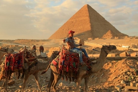 1月24日，商販騎駱駝離開埃及吉薩金字塔景區(qū)。新華社記者 隋先凱 攝