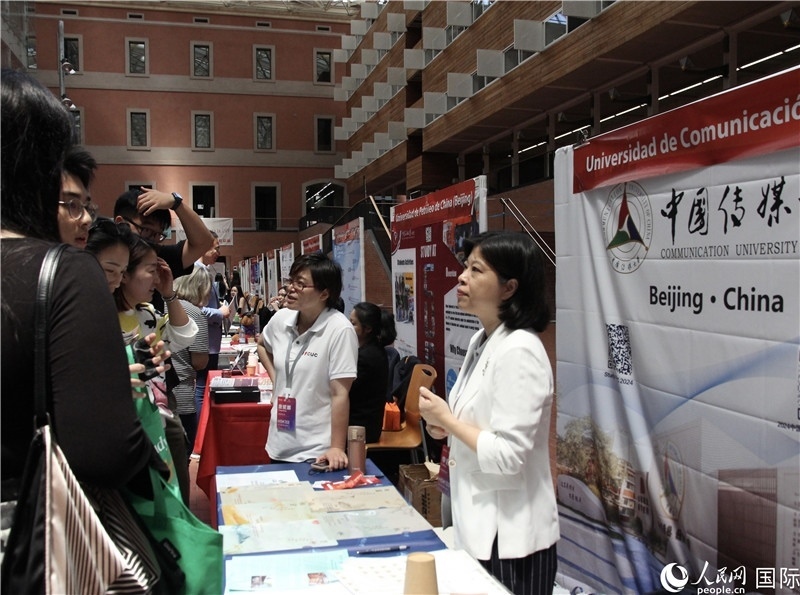 旅西華人華僑在展臺(tái)前咨詢。人民網(wǎng)記者 許海林?jǐn)z