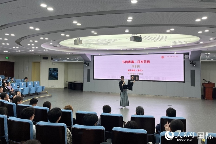 日本大學(xué)生介紹能樂知識。人民網(wǎng)記者 陳思攝