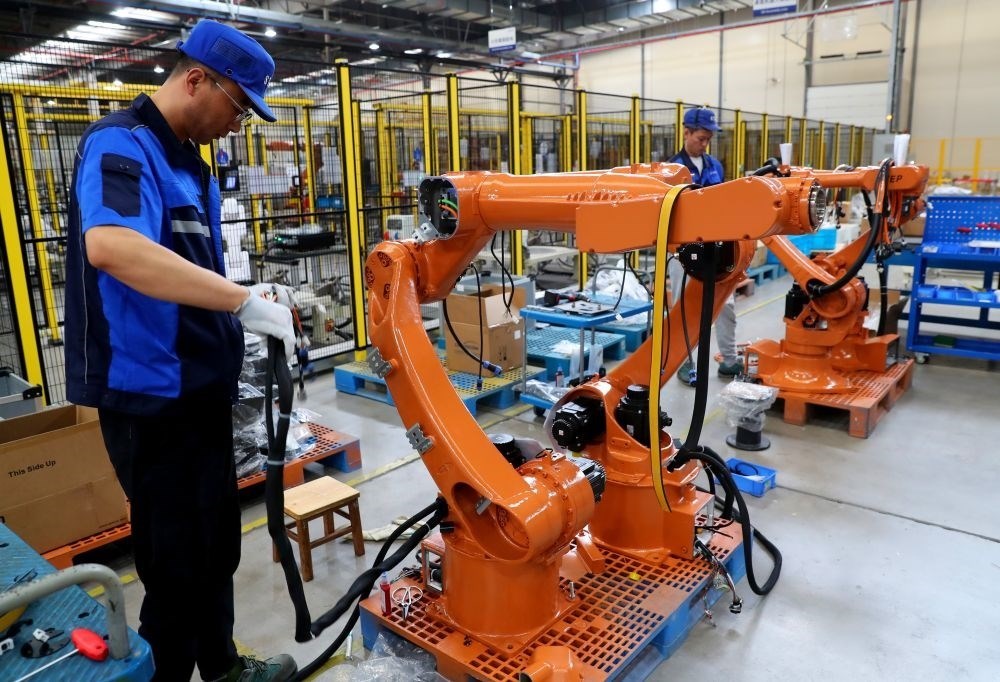 工作人員在上海新時(shí)達(dá)機(jī)器人有限公司位于嘉定的智能工廠內(nèi)忙碌（2024年5月23日攝）。新華社記者 龔兵 攝