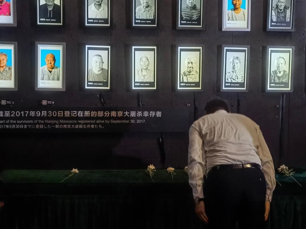 7月18日，人們向離世的南京大屠殺幸存者獻(xiàn)花、鞠躬。新華社記者邱冰清 攝