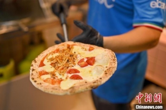 近日，韋榮耀展示他制作的“老友味”披薩。 俞靖 攝