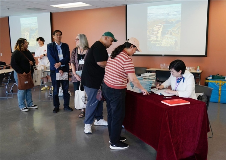 作者顧春芳在活動(dòng)現(xiàn)場(chǎng)簽名贈(zèng)書。羅先勇攝