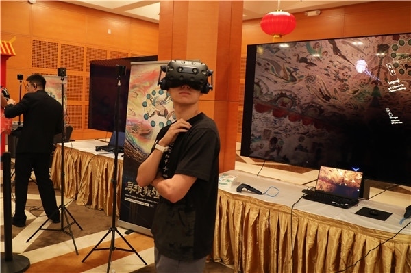 1、在本次活動的展覽現(xiàn)場，敦煌研究院與騰訊展示了“數(shù)字藏經(jīng)洞”和“尋境敦煌”等創(chuàng)新互動產(chǎn)品。圖為當(dāng)?shù)孛癖娡ㄟ^VR虛擬游覽洞窟。 人民網(wǎng)記者 李志偉攝
