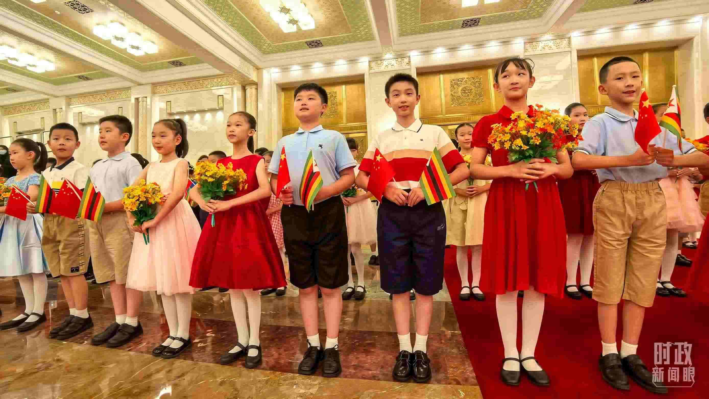 △現(xiàn)場歡迎津巴布韋總統(tǒng)訪華的青少年。（總臺央視記者鐘銳拍攝）