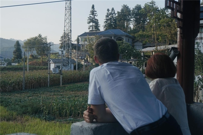 望得見(jiàn)山，看得見(jiàn)水，記得住鄉(xiāng)愁。每個(gè)人心中都有一個(gè)屬于自己的“花茂村”，在這方心田，走遍千山萬(wàn)水，鄉(xiāng)音未改鬢毛衰。吉爾吉斯斯坦《比什凱克晚報(bào)》第一副總編輯妮娜·尼奇博洛娃與《中國(guó)與俄羅斯》雜志社社長(zhǎng)奧列格·別列日內(nèi)赫攝在花茂村民居屋檐下并肩佇立，眺望山水，尋覓鄉(xiāng)愁。（李光裕攝）