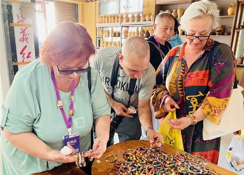歐亞媒體考察團(tuán)成員在母氏陶藝館內(nèi)挑花了眼，色彩絢麗、質(zhì)地均勻的陶藝手串讓他們愛(ài)不釋手?！斑@里的東西都太實(shí)惠了！”塔吉克斯坦《索格特真理報(bào)》政論部主任娜塔利婭·多羅費(fèi)耶娃說(shuō)?；宓奶厣a(chǎn)品物美價(jià)廉，讓考察團(tuán)成員為家人好友買(mǎi)到了心儀的禮物，也為此次以四川成都為起點(diǎn)，路經(jīng)南充、廣安至貴州遵義的考察行程畫(huà)上了圓滿(mǎn)句號(hào)。（張亞欣攝）