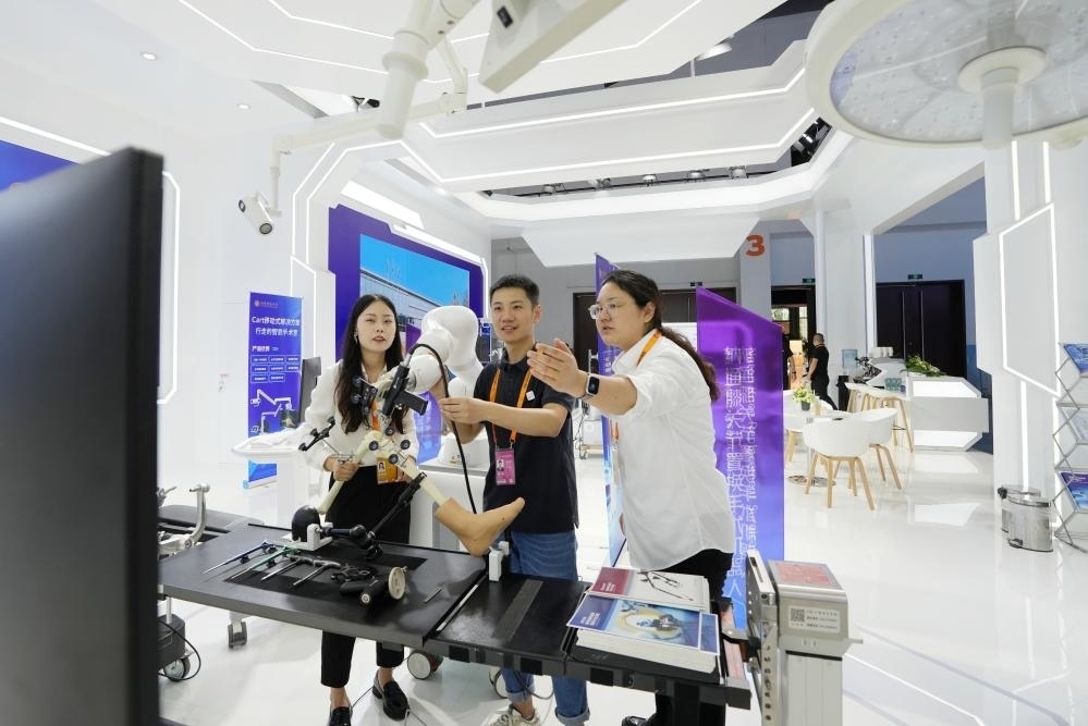 9月11日，一位媒體記者（中）在2024年服貿(mào)會國家會議中心會場體驗(yàn)北京納通科技集團(tuán)有限公司的膝關(guān)節(jié)置換手術(shù)機(jī)器人。新華社記者鞠煥宗 攝