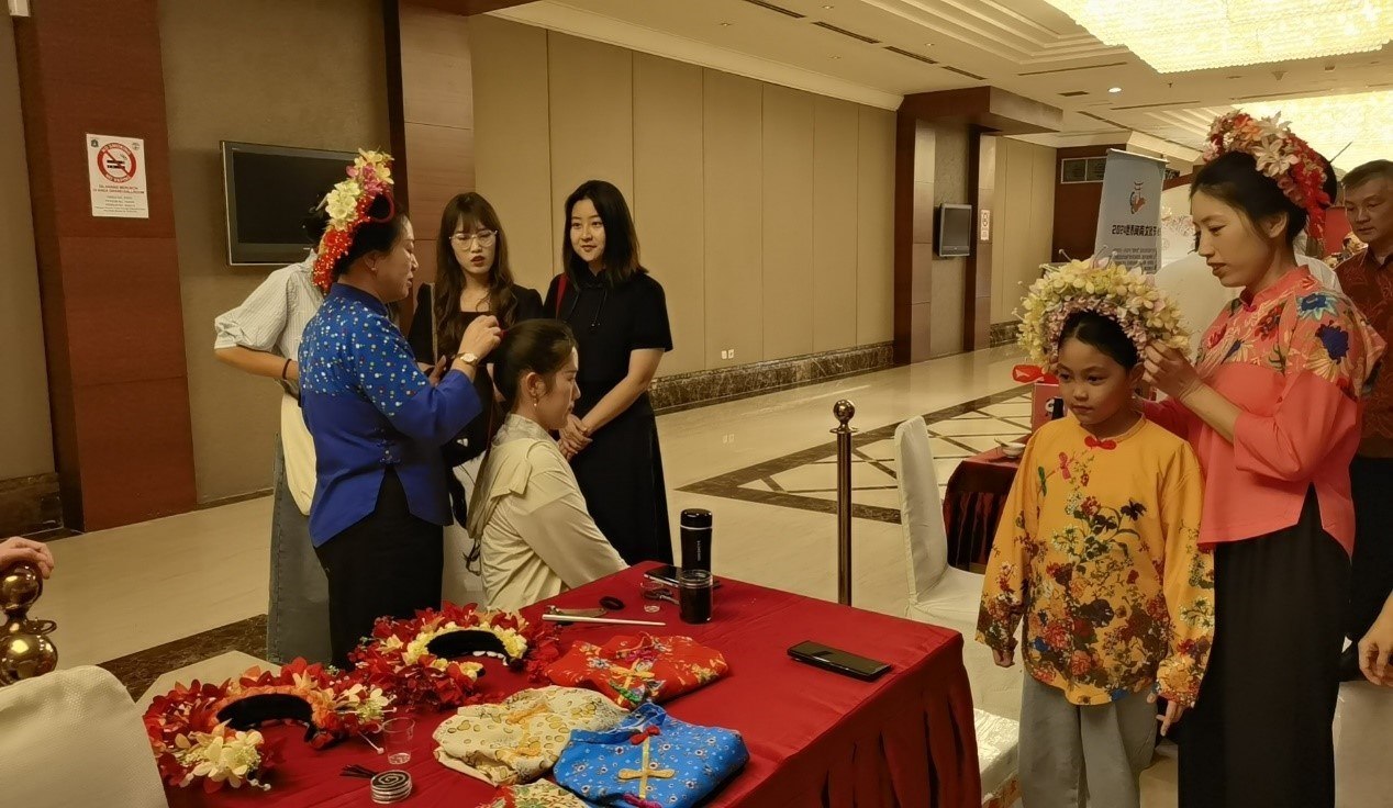 阿拉扎大學(xué)孔子學(xué)院志愿者老師向傳承人學(xué)習(xí)簪花圍。阿拉扎大學(xué)孔子學(xué)院供圖