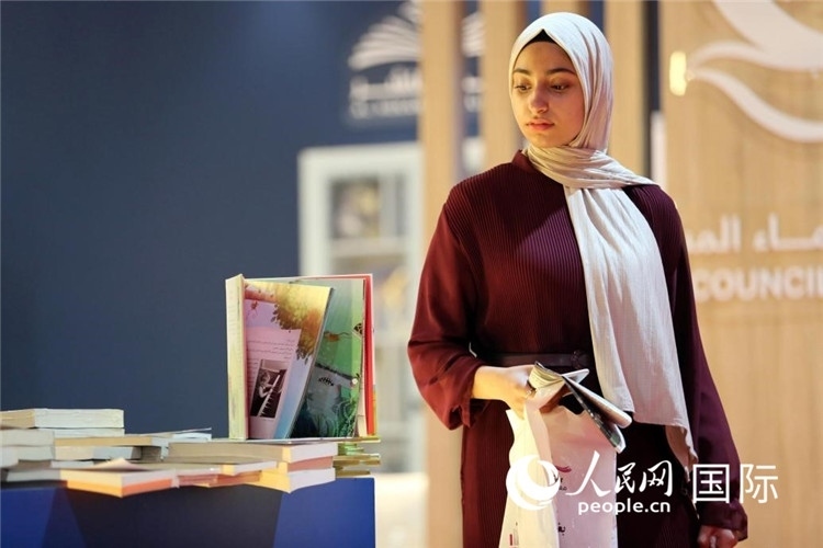 一名女性走過展臺。人民網(wǎng) 奧馬爾·哈利勒攝