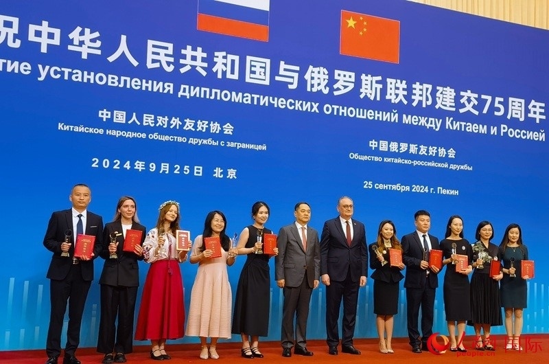 楊萬明會長和莫爾古洛夫大使為10位中俄青年友好微視頻創(chuàng)意大賽獲獎代表頒獎。人民網(wǎng)記者 李明琪攝