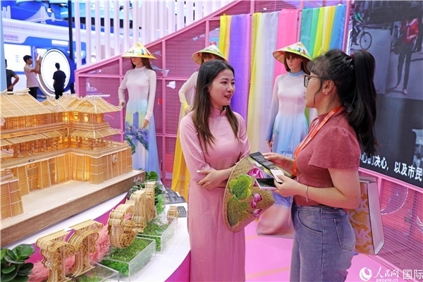 參觀者在東博會(huì)越南展區(qū)同工作人員咨詢交談。人民網(wǎng)記者 趙益普攝