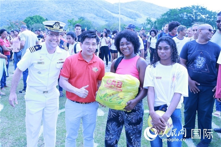 巴西中國浙江商會會長鄭俠茂向巴西貧困社區(qū)兒童及家庭捐贈基礎食品籃子和足球。人民網(wǎng)記者陳海琪 攝