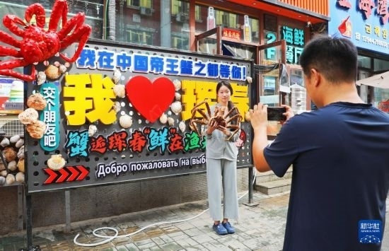9月21日，游客在吉林省琿春市一處帝王蟹元素主題裝飾前拍照留念。新華社發(fā)