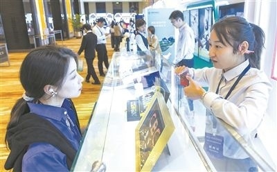 在北京麗澤商務(wù)區(qū)，工作人員（右一）介紹數(shù)字人民幣SIM卡硬錢包。新京報記者 陶冉攝