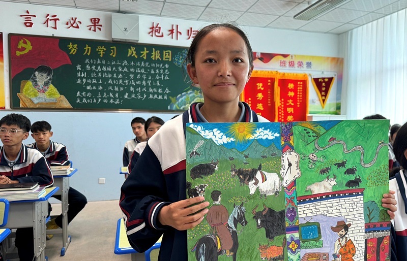 果洛西寧民族中學(xué)學(xué)生尼東拉毛在主題思政課上展示表現(xiàn)現(xiàn)代化家鄉(xiāng)的作品。