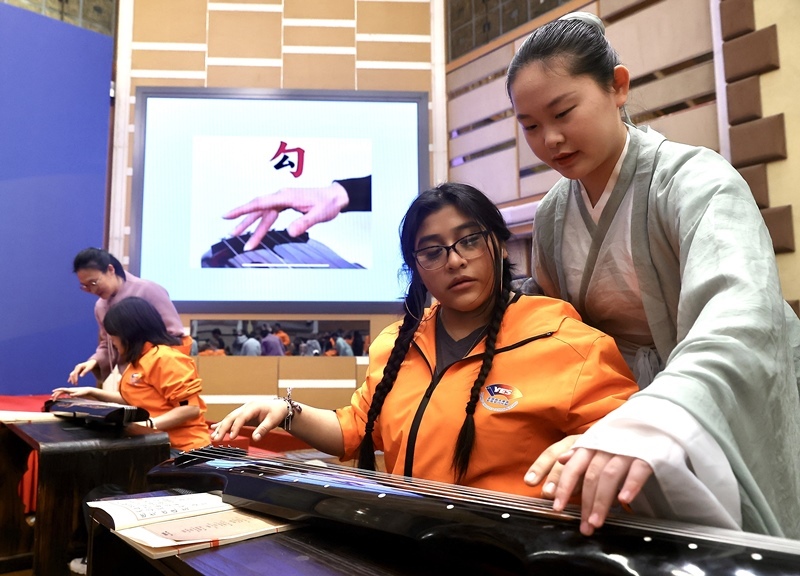 2024年3月20日，美國(guó)華盛頓州中學(xué)生代表團(tuán)北京大學(xué)交流活動(dòng)在北京大學(xué)英杰交流中心舉行。圖為來(lái)自華盛頓州的中學(xué)生體驗(yàn)古琴。