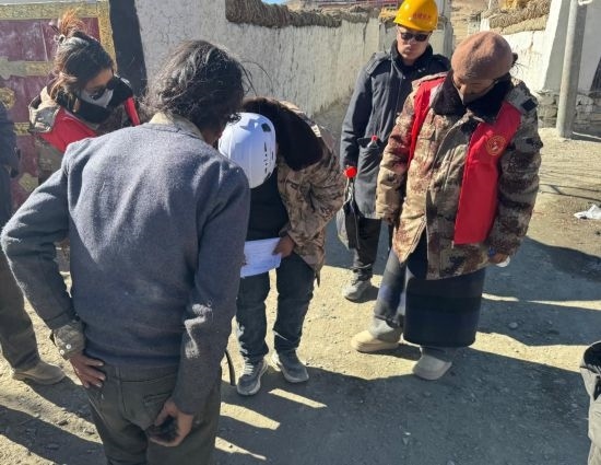 1月13日，次旺（右一）陪同工作組走訪(fǎng)村莊，評(píng)估房屋受損程度。新華社發(fā)