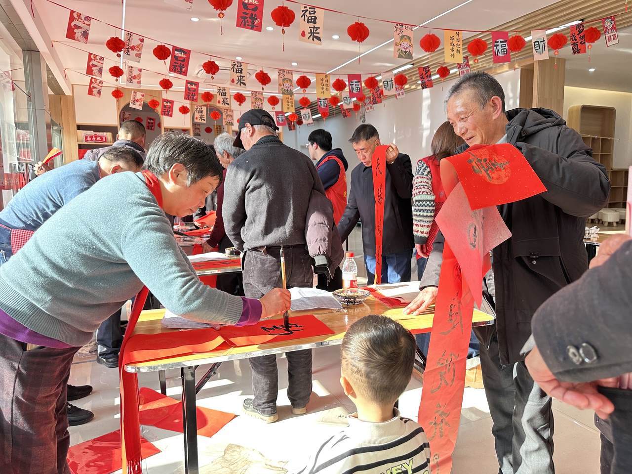 今年春節(jié)前夕，慶元縣濛洲街道同濟(jì)新村，一場送春聯(lián)活動熱鬧舉行。慶元縣融媒體中心 供圖