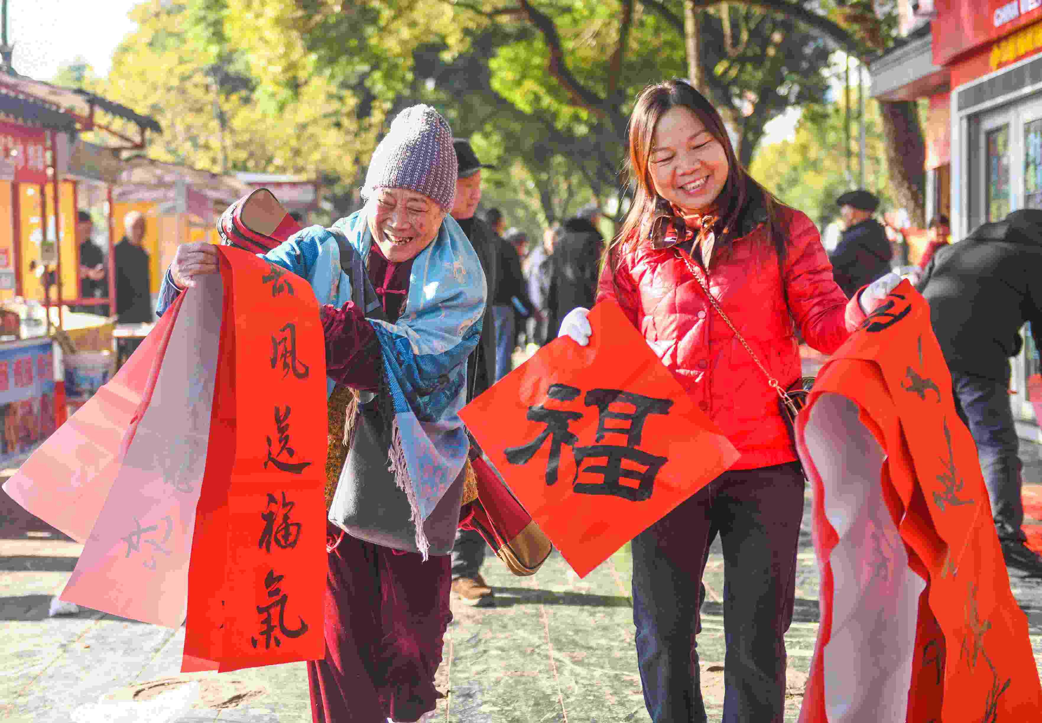2025年1月13日，在湖南省永州市道縣西洲公園義工崗亭，市民們領到了書法志愿者為大家書寫的春聯(lián)。