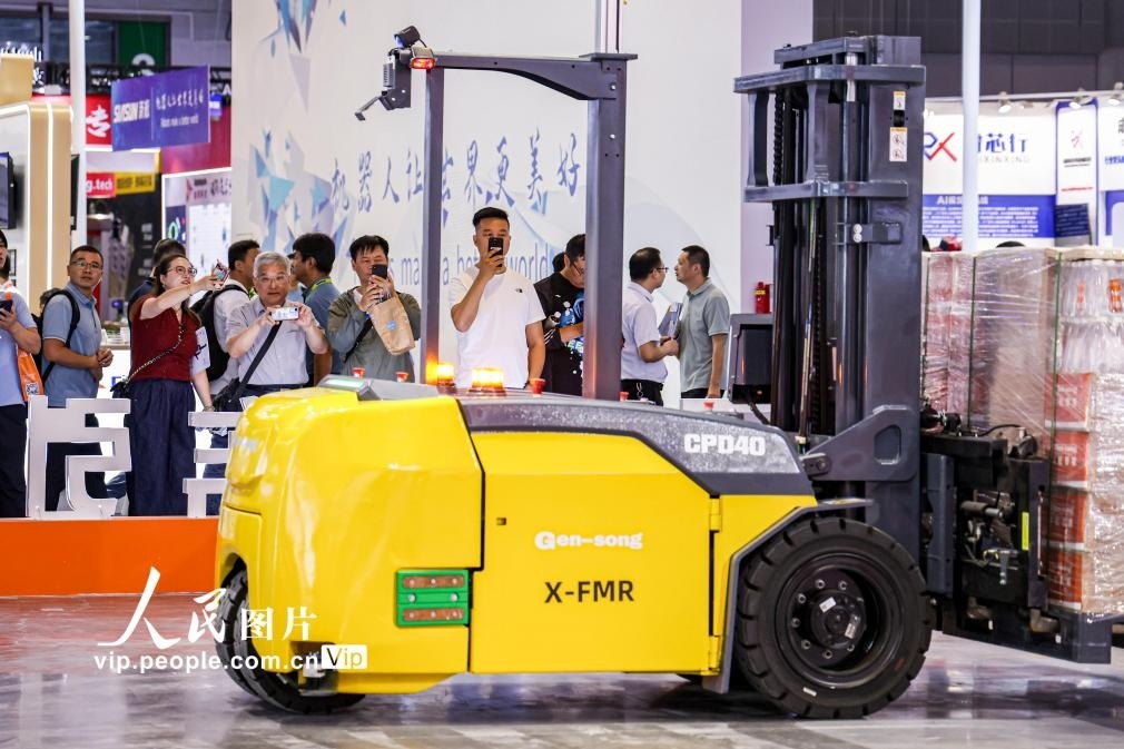 第24屆中國(guó)工博會(huì)現(xiàn)場(chǎng)，觀眾觀看叉取機(jī)器人作業(yè)演示。王初攝（人民圖片網(wǎng)）