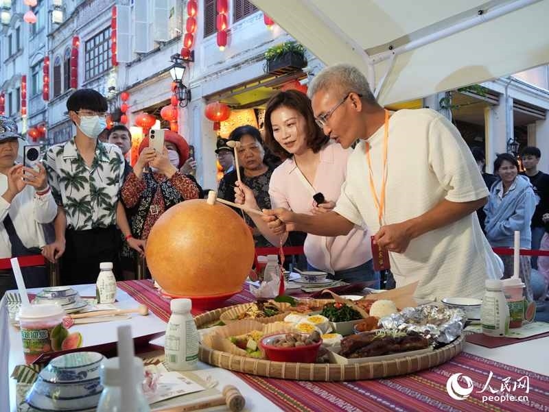 嘉賓品嘗海南傳統(tǒng)美食“煎堆”。人民網(wǎng)記者 張力洋攝