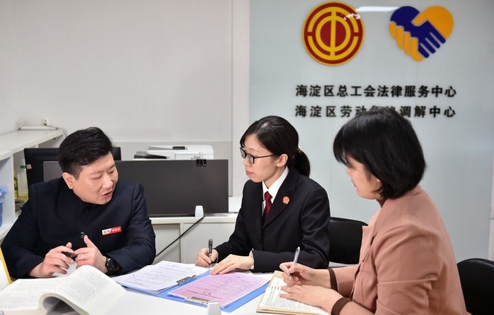2025年3月6日，在北京市海淀區(qū)總工會勞動爭議調(diào)解中心，海淀區(qū)人民法院法官王琰（中）與該中心工作人員就糾紛化解情況進(jìn)行溝通。新華社記者 趙婷婷 攝