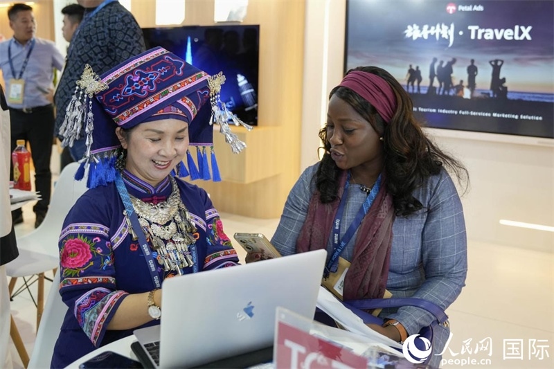 來(lái)自廣西的旅游業(yè)者同客戶交流。人民網(wǎng)塔里克·易卜拉欣攝