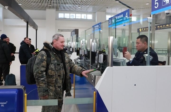 2024年12月10日，在黑河公路口岸旅檢大廳，黑河出入境邊防檢查站民警為首班次客車入境旅客辦理邊檢通關(guān)手續(xù)。當(dāng)日，中國黑河公路口岸—俄羅斯卡尼庫爾干公路口岸旅客運(yùn)輸正式開通。新華社發(fā)（劉松攝）