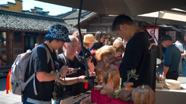 “五一”期間，游客正在烏鎮(zhèn)“水鄉(xiāng)碼頭”挑選購買文創(chuàng)產(chǎn)品。受訪者供圖