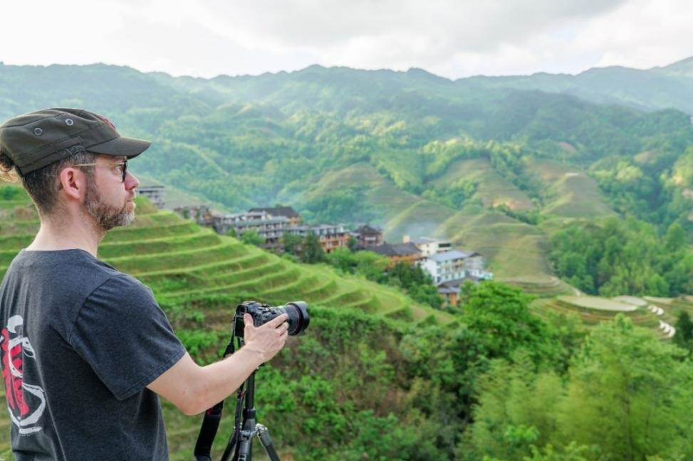 2025年年5月9日，廣西桂林，外國游客游覽龍脊梯田，在美景前駐足拍照。（圖片來源：視覺中國）