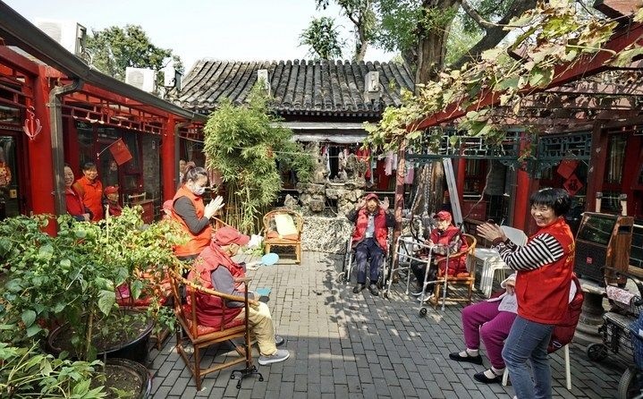 2024年10月12日，鐘樓灣胡同的老年人在社區(qū)內(nèi)的四合院養(yǎng)老驛站休閑。2017年起，北京市先后開展了兩輪背街小巷環(huán)境整治提升行動(dòng)，完整保留了中軸線生活建筑群的歷史信息，并根據(jù)居民的生活和居住方式進(jìn)行適配化的更新和改造，極大地改善了生活環(huán)境。2023年鐘樓灣胡同被評(píng)為“北京最美街巷”。