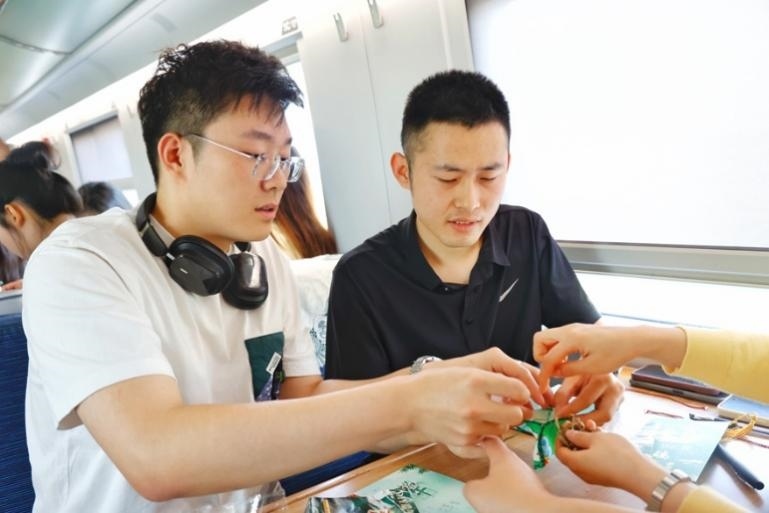 G232次旅客親手制作端午荷包和五彩繩。王磊攝