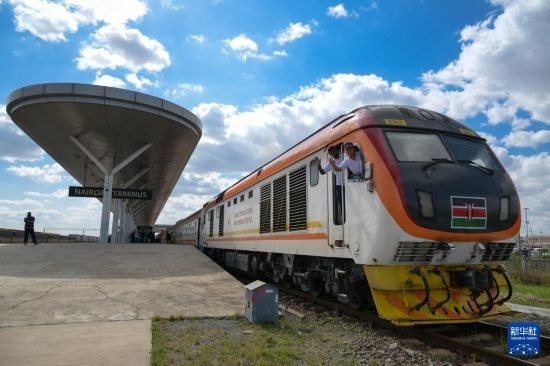 5月31日，在蒙內(nèi)鐵路內(nèi)羅畢站，機(jī)車駕駛員蔣立平（右）和博爾在即將開往蒙巴薩的E2次列車上揮手致意。新華社記者 楊光 攝
